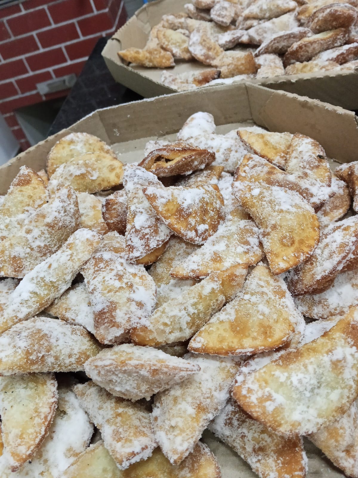 Pastéis doces polvilhados com açúcar servidos em caixas