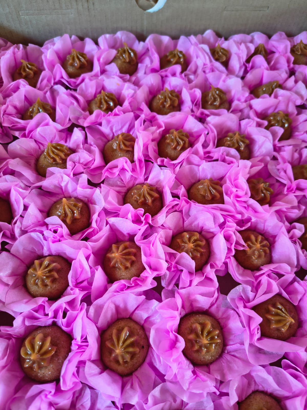 Doces finos em forminhas rosa com cobertura caramelada