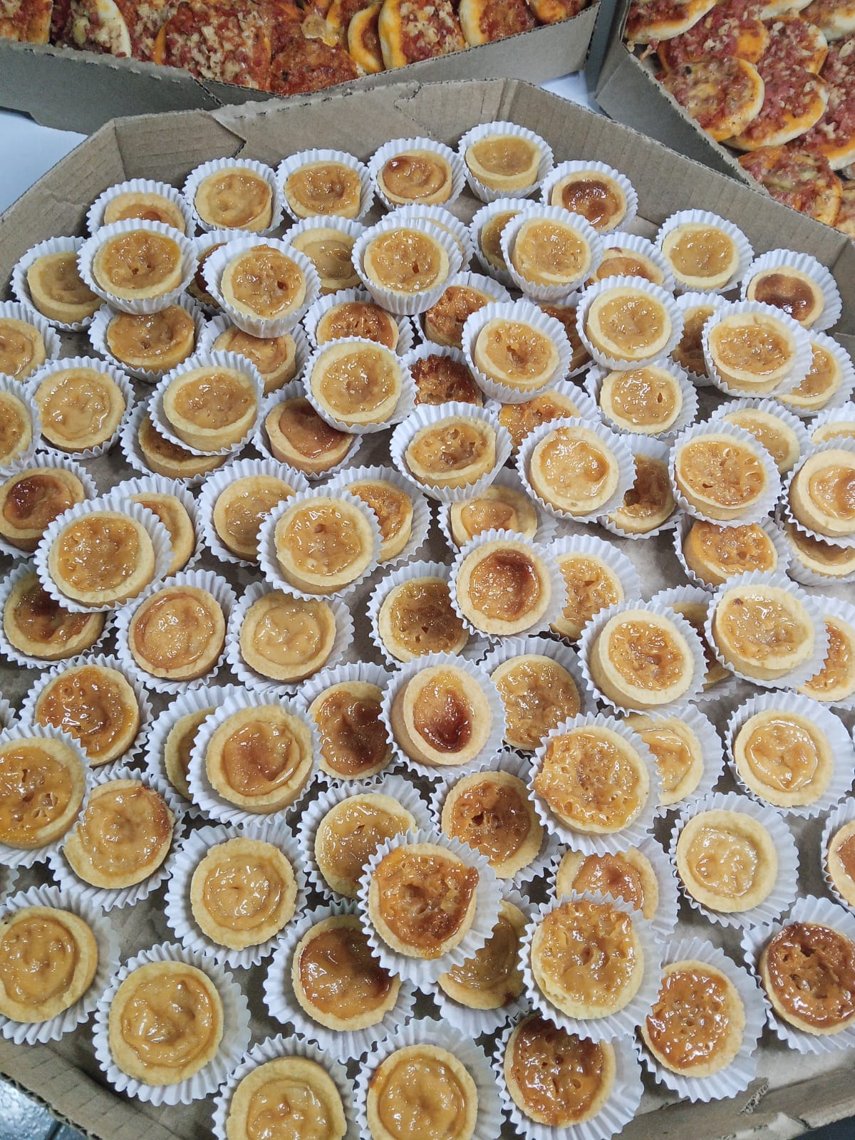 Bandeja com dezenas de tortinhas doces em forminhas de papel