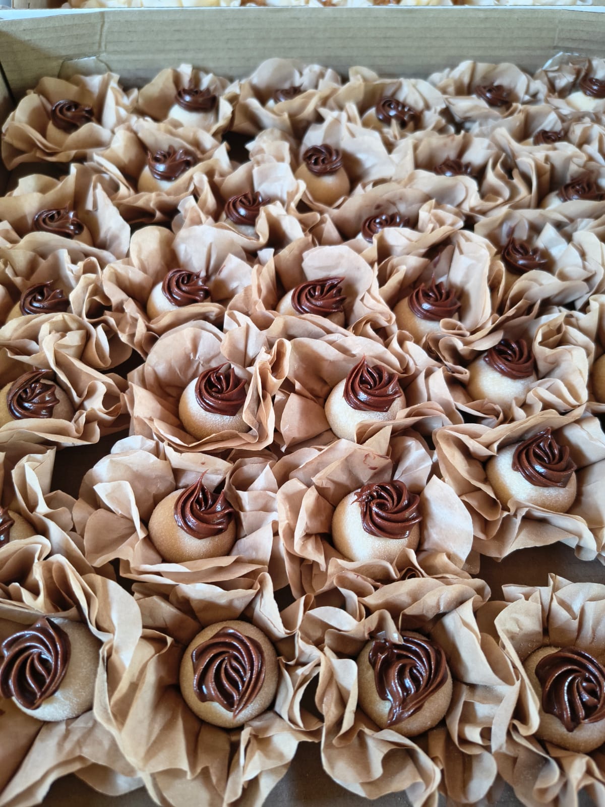 Caixa com doces finos de massa clara cobertos com chocolate